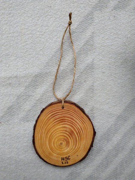 A slice of wood hung on twine as an ornament.